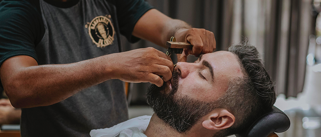 Man having his beard trimmed.