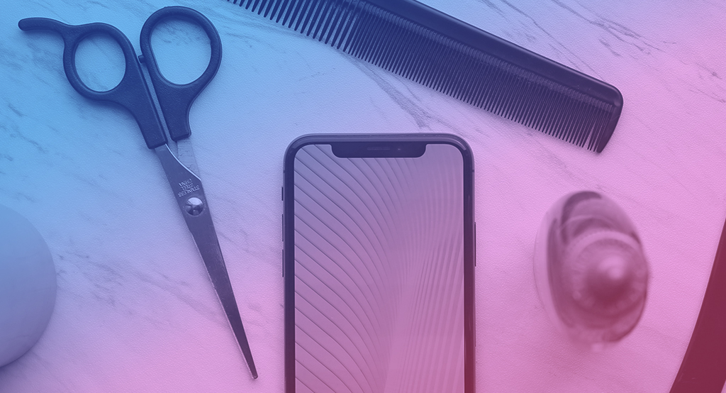 a phone, scissors and a comb on a wood surface.